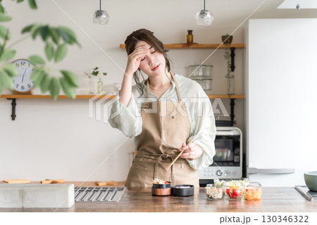 キッチンでお弁当を詰める女性(疲労・疲れ・大変・負担・過労・苦労) キッチンでお弁当を詰める女性(疲労・疲れ・大変・負担・過労・苦労) 130346322