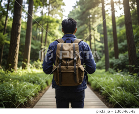 森の遊歩道を歩くリュック姿の男性の後ろ姿 130346348