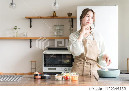キッチンでお弁当を作りながら考える,悩む若いアジア人女性 130346386