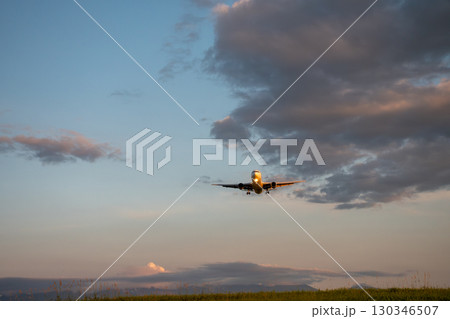 夕日を浴びる着陸体制のジェット機 夕日を浴びる着陸体制のジェット機 130346507