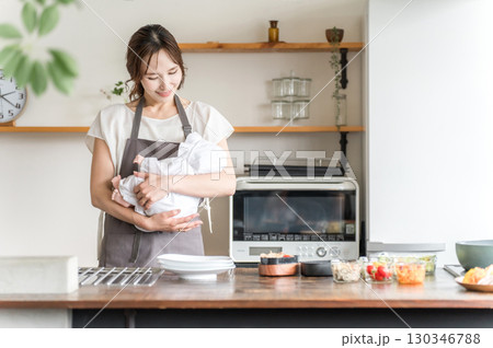 キッチンで赤ちゃんを抱っこする若いアジア人女性 130346788