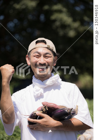 畑で野菜を収穫する男性 農家や農業で働くする人のイメージ カメラ目線の笑顔のクローズアップ 畑で野菜を収穫する男性 農家や農業で働くする人のイメージ カメラ目線の笑顔のクローズアップ 130346918