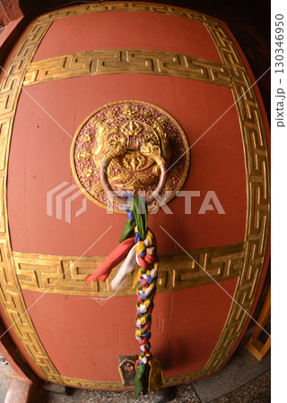 The ancient Tibet styles door handle or door knocker made from brass on red door. The ancient Tibet styles door handle or door knocker made from brass on red door. 130346950