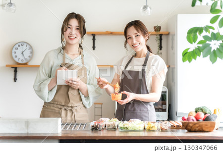 料理教室・クッキングスクールで料理を教える講師の女性と生徒の女性 130347066