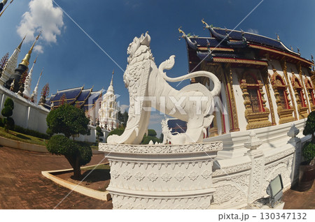 Statues of white Singha, which are animals in Thai art, decorate the front of the Church or Chapel and pagoda at Wat Den Sali Si Mueang Kaen temple. Located at Chaing Mai Province in Thailand. 130347132