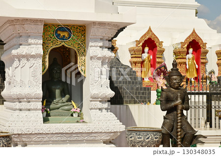 Stone Buddha statues in niches and outdoor standing Buddha statues and giants in front of the 12 Zodiac pagodas at Wat Den Salisri Mueang Kaen temple. 130348035
