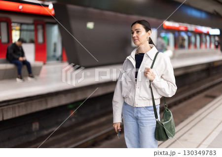 Portrait of woman at metro station waiting for train Portrait of woman at metro station waiting for train 130349783