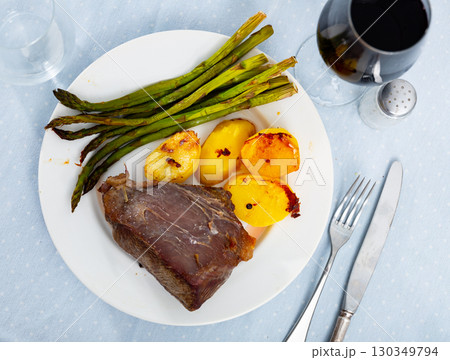 Grilled veal served with potato and asparagus 130349794