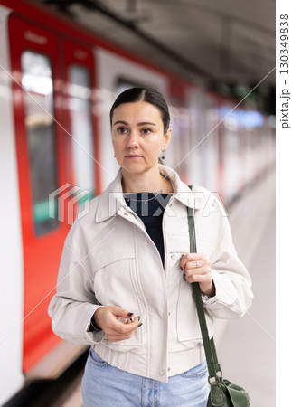 Female passenger awaits the metro train at arrival station Female passenger awaits the metro train at arrival station 130349838