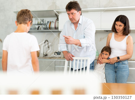 Parents scolding their son in kitchen at home 130350127