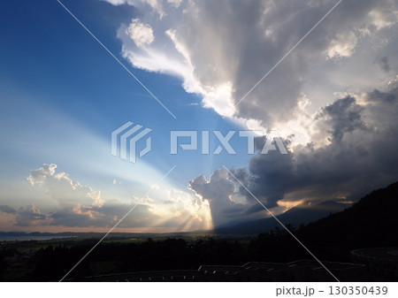 夏の夕方、太陽が積乱雲に隠れ、放射状の光が広がる。ドラマチックで綺麗だ。 130350439