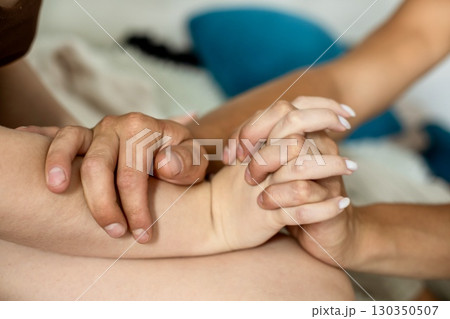 Close of a man gently holding a woman hands with care and support, symbolizing love, tenderness 130350507