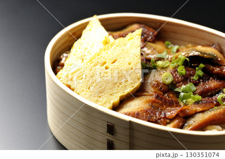 曲げわっぱ入り鰻丼弁当を黒背景で撮影 130351074