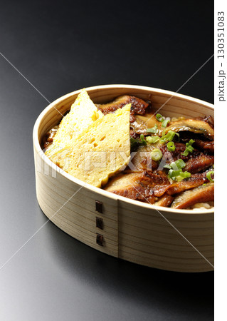 曲げわっぱ入り鰻丼弁当を黒背景で撮影 130351083