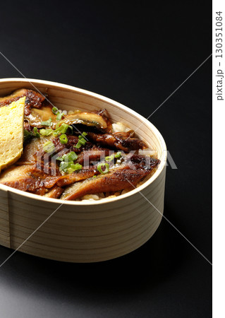 曲げわっぱ入り鰻丼弁当を黒背景で撮影 130351084