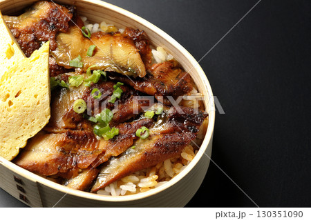 曲げわっぱ入り鰻丼弁当を黒背景で撮影 130351090