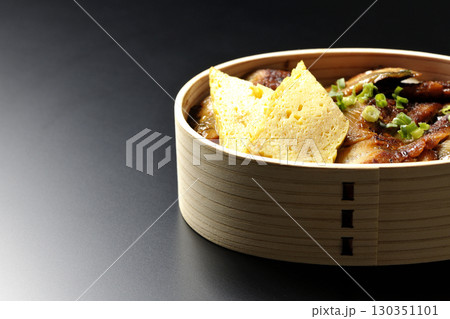 曲げわっぱ入り鰻丼弁当を黒背景で撮影 130351101