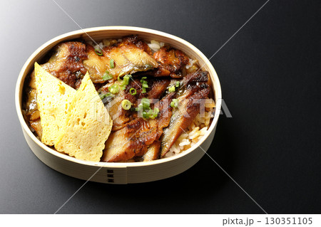 曲げわっぱ入り鰻丼弁当を黒背景で撮影 130351105