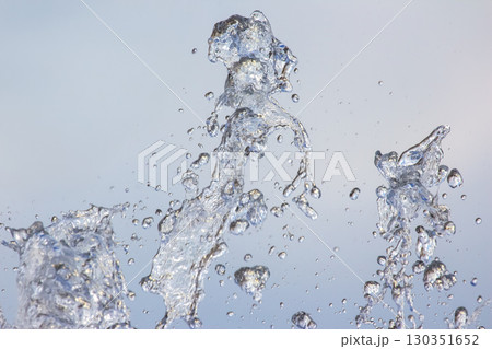 Water droplets create vibrant patterns in a fountain during daylight hours Water droplets create vibrant patterns in a fountain during daylight hours 130351652