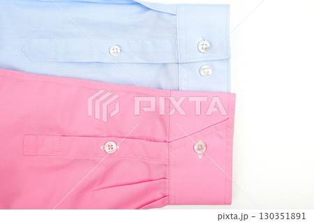 Shirts in light blue and pink colors folded neatly on a white surface 130351891