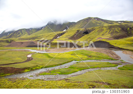 Summer in Iceland's highlands features mossy hills and a winding river 130351903