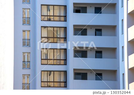 Modern apartment building with glass balconies in a sunny urban area 130352044