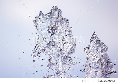 Water splashes up from a fountain under a clear sky during a sunny afternoon Water splashes up from a fountain under a clear sky during a sunny afternoon 130352048