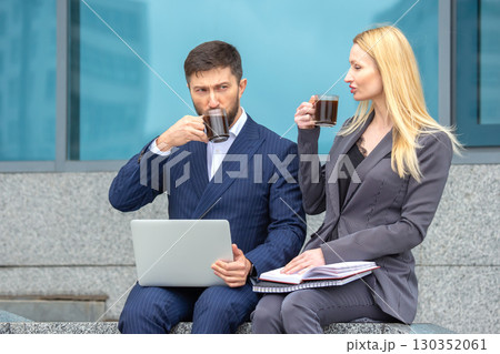 Business professionals having coffee while working on laptops in an urban setting Business professionals having coffee while working on laptops in an urban setting 130352061