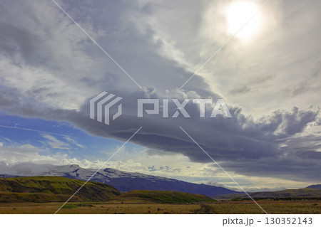 Majestic Icelandic landscape showcasing dramatic clouds over mountains and fields 130352143