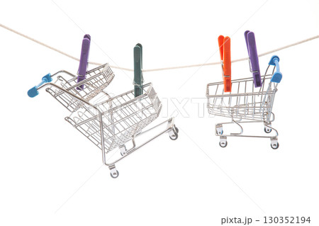Mini shopping carts hanging on a clothesline with colorful clips in a creative display 130352194