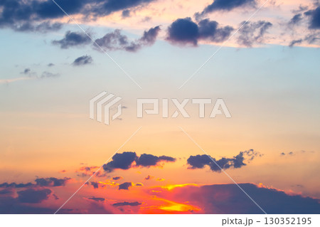 Beautiful sunset over a tranquil sky with vibrant clouds and warm colors near the horizon 130352195