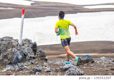 Runner navigating rocky terrain in Iceland's dramatic landscape during summer 130352207