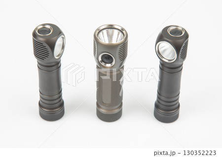 Three modern flashlights arranged in a row showcasing different designs and features 130352223
