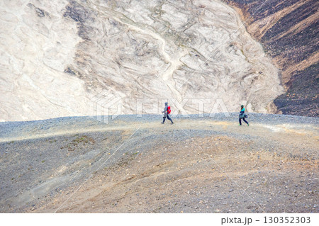 Hikers exploring the rugged terrain of Iceland's stunning landscape on an adventure 130352303