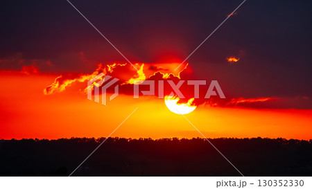 Stunning sunset paints the sky with vibrant hues over a distant horizon 130352330