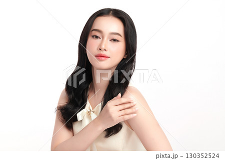 A beautiful young Asian woman with clean, fresh skin against a white background. Skincare, facial treatment, cosmetology, beauty, and spa. An elegant portrait of an Asian woman. 130352524