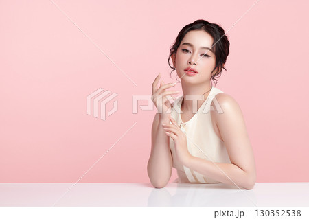 A beautiful young Asian woman with clean, fresh skin against a pink background. Skincare, facial treatment, cosmetology, beauty, and spa. An elegant portrait of an Asian woman. A beautiful young Asian woman with clean, fresh skin against a pink background. Skincare, facial treatment, cosmetology, beauty, and spa. An elegant portrait of an Asian woman. 130352538