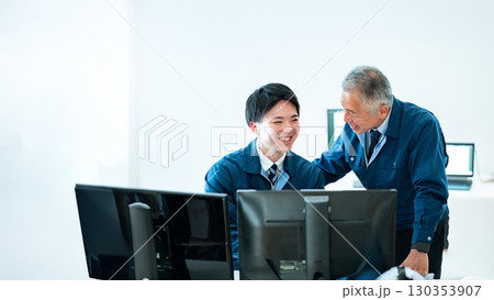 作業着の若手社員とベテラン社員の会話 130353907