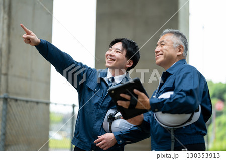 建設現場で会話する若手とベテラン技術者 130353913