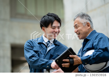 建設現場で会話する若手とベテラン技術者 130353916