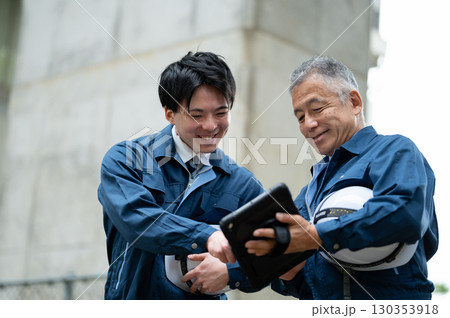 建設現場で会話する若手とベテラン技術者 130353918