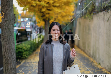 秋の街を散策する女性のポートレート 130354119