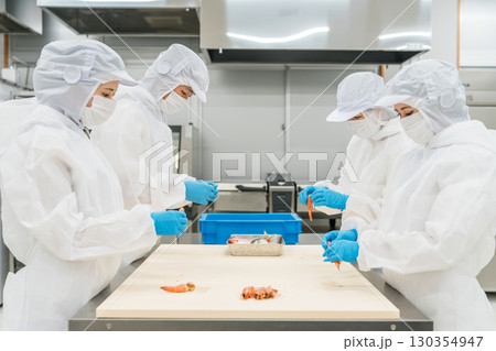 衛生服を着て食品加工の仕事をする男女スタッフ（食品衛生,食品工場,衛生管理) 130354947