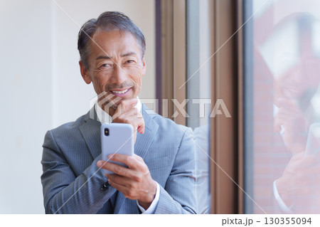スマホを使うシニアビジネスマン スマホを使うシニアビジネスマン 130355094