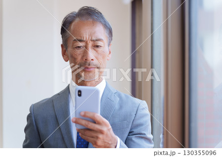 スマホを使うシニアビジネスマン スマホを使うシニアビジネスマン 130355096