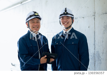 作業着姿の若手とベテラン 130356357