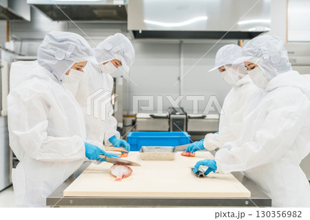 魚を調理する衛生服姿の男女スタッフ（調理師・料理人・生鮮市場・食品加工） 130356982