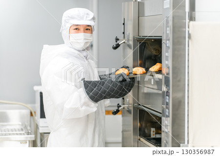 パン工場,食品工場で働く防塵服,クリーンスーツを着た製造スタッフの男性 パン工場,食品工場で働く防塵服,クリーンスーツを着た製造スタッフの男性 130356987