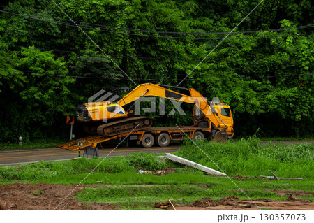 Excavator on Trailer Truck for Flood Recovery and Road Repair Excavator on Trailer Truck for Flood Recovery and Road Repair 130357073