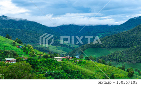 Mountain Village with Green Hills and Clouds 130357105